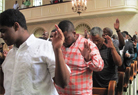 Men in church lifting hands praising God jpg